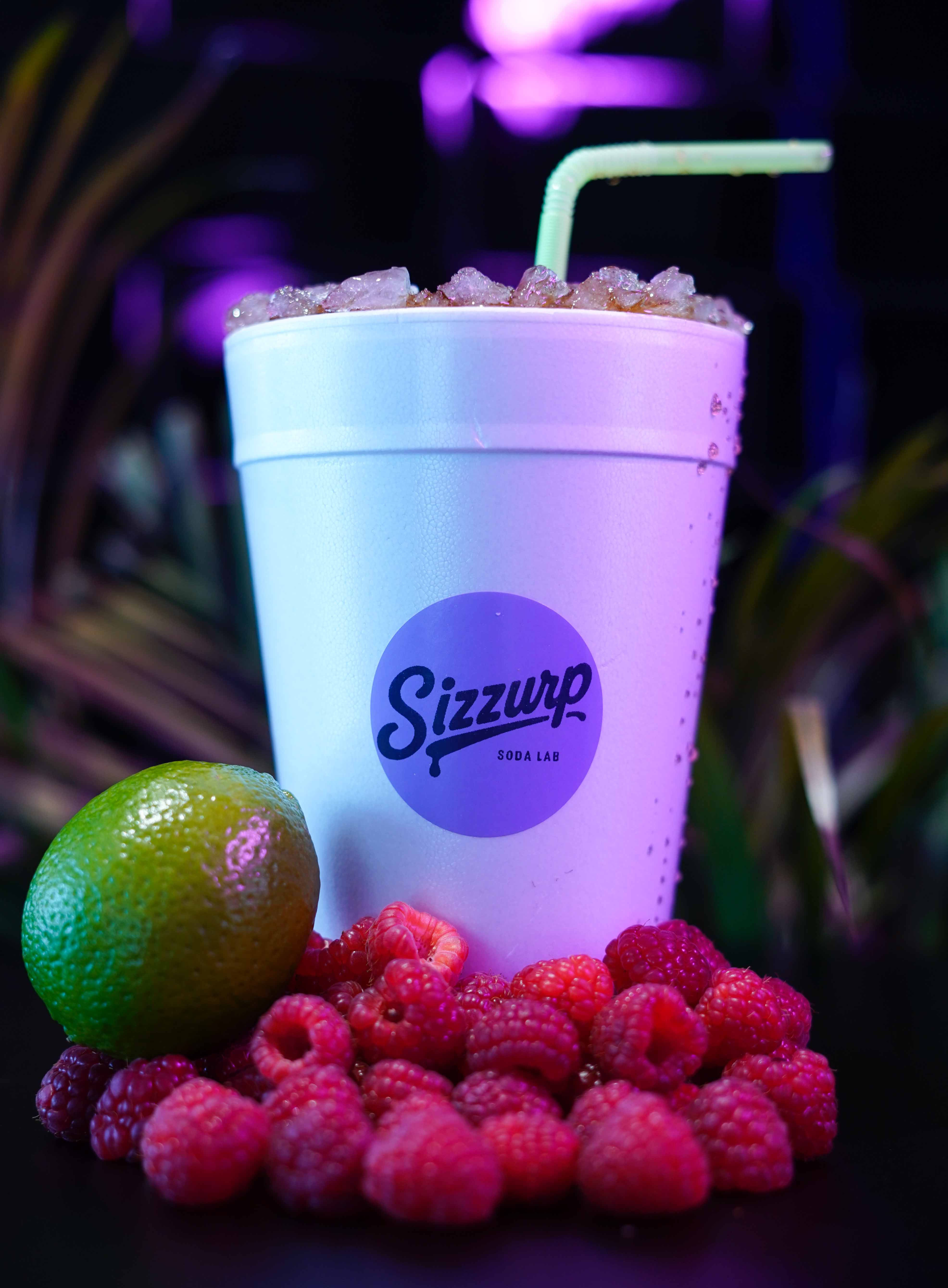 Close-up of a colorful Sizzurp custom dirty soda with syrup layers and toppings