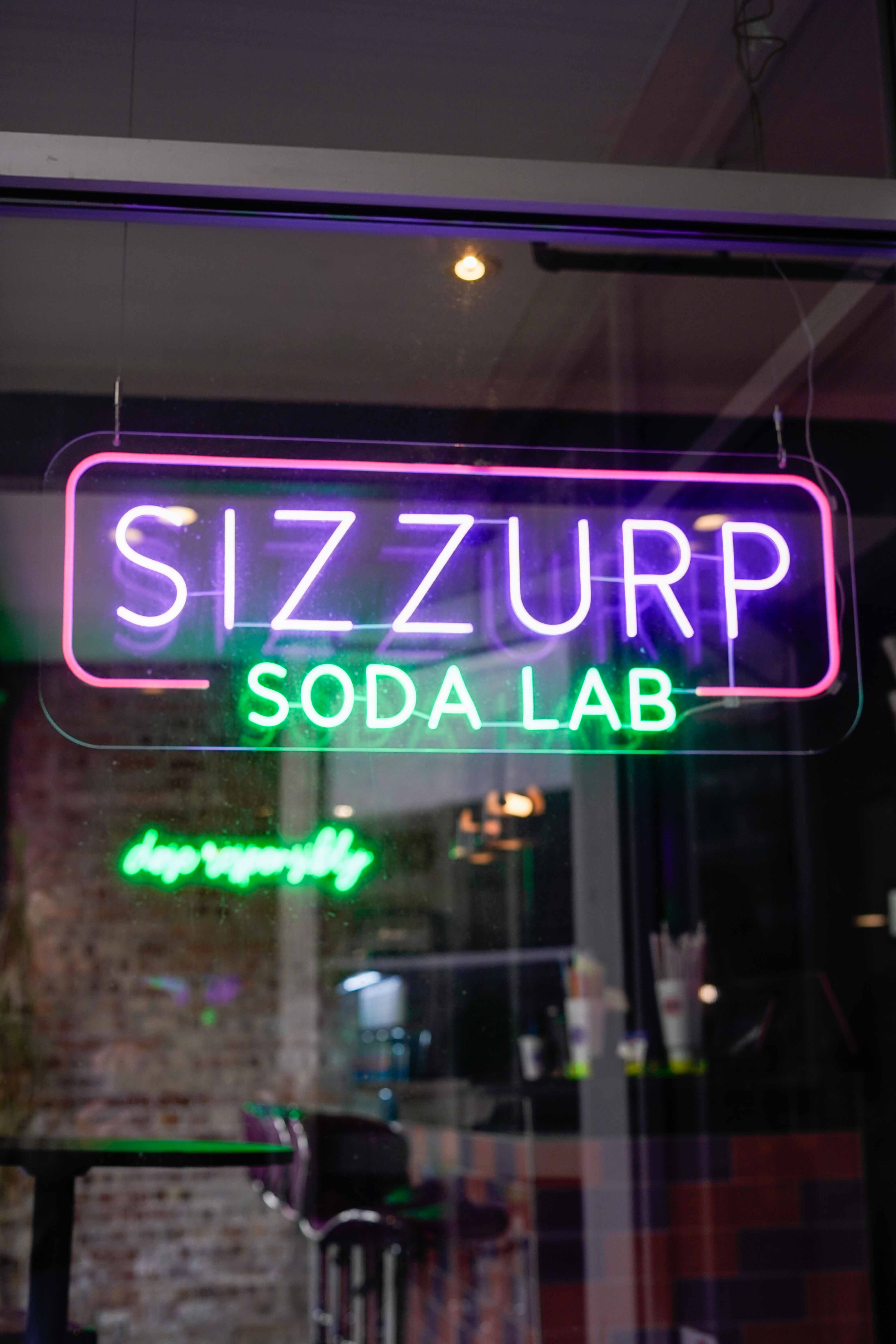 Sizzurp Soda Lab branded cups with vibrant drink colors
